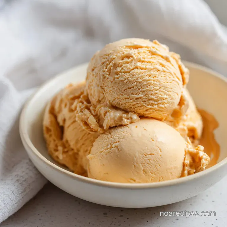 A perfect scoop of pale gold ice cream, topped with crunchy toffee shards and a delicate drizzle.
